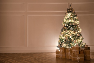 Photo of Beautiful decorated Christmas tree and gifts indoors. Space for text