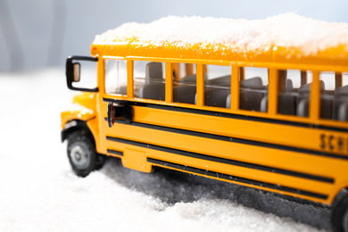 Yellow school bus on snowy road, closeup. Transport for students