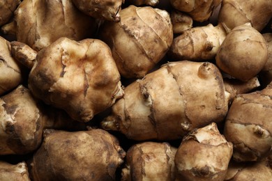 Many fresh Jerusalem artichokes as background, top view