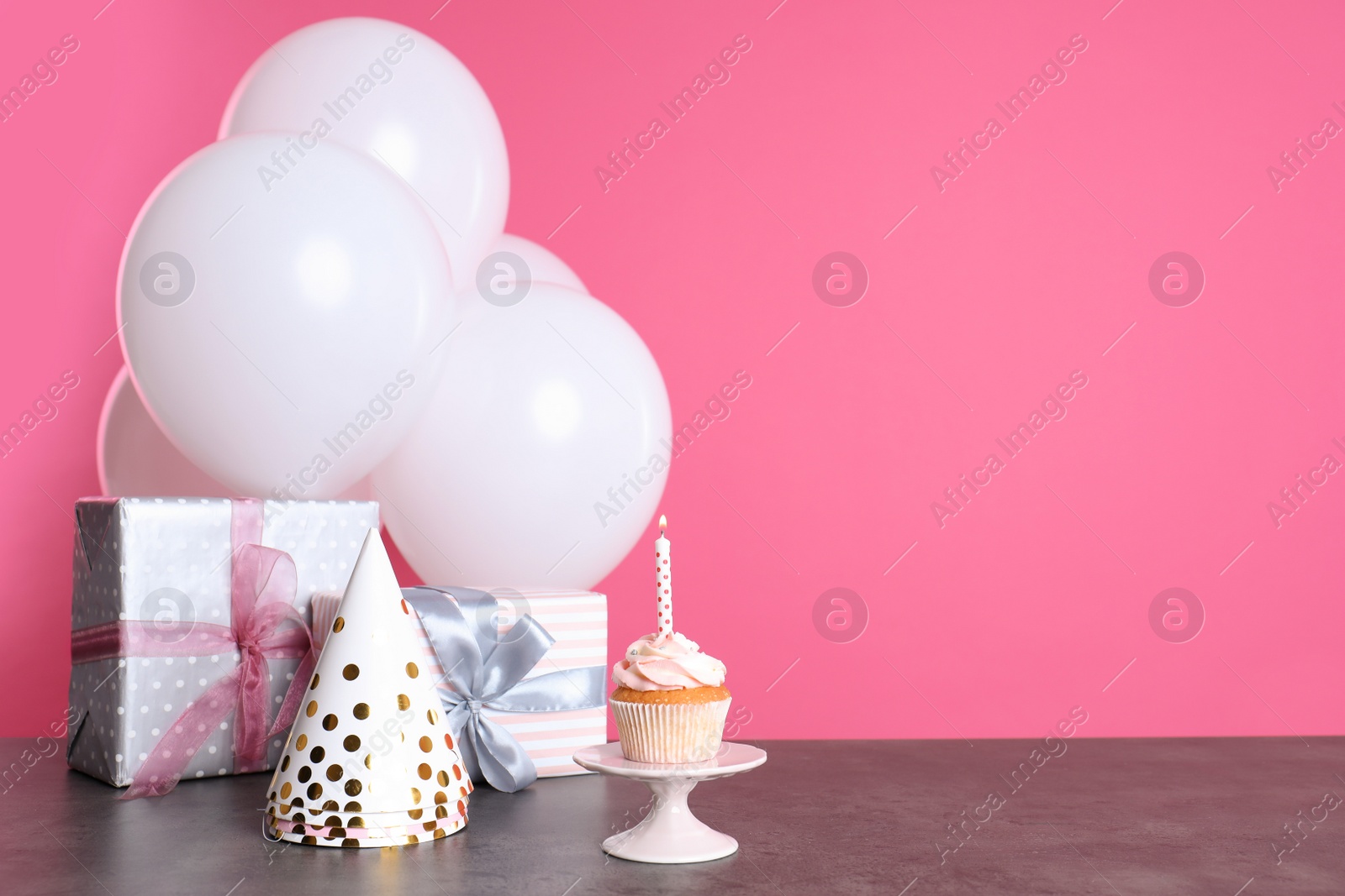 Photo of Composition with birthday cupcake, presents and balloons on table. Space for text