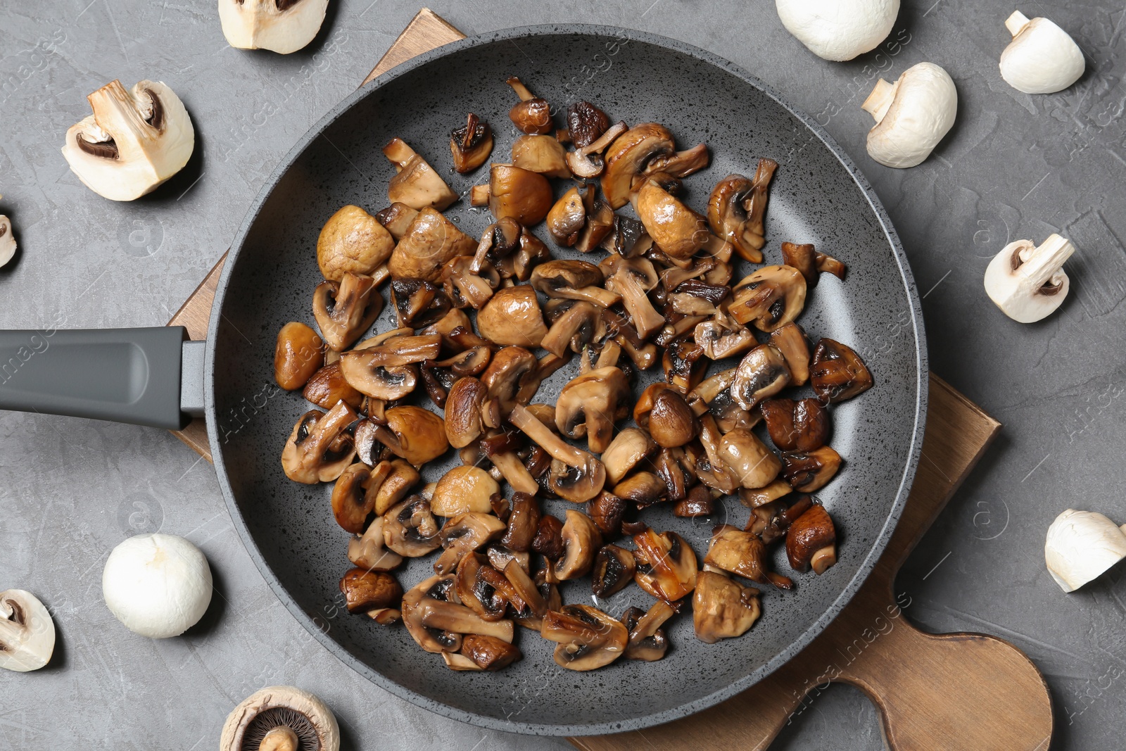 Photo of Frying pan with mushrooms on grey background, flat lay