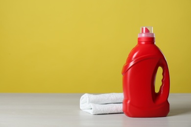 Photo of Bottle of cleaning product and microfiber cloth on light table. Space for text