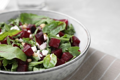 Photo of Delicious beet salad served in bowl on table, closeup