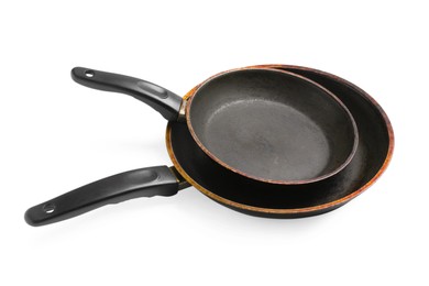 Dirty old frying pans on white background