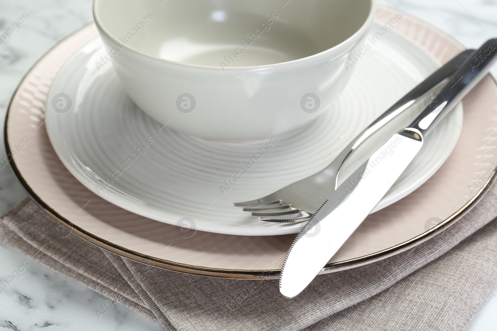 Photo of Clean plates, bowl, cutlery and napkin on table, closeup