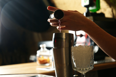 Photo of Bartender preparing fresh alcoholic cocktail at bar counter, closeup