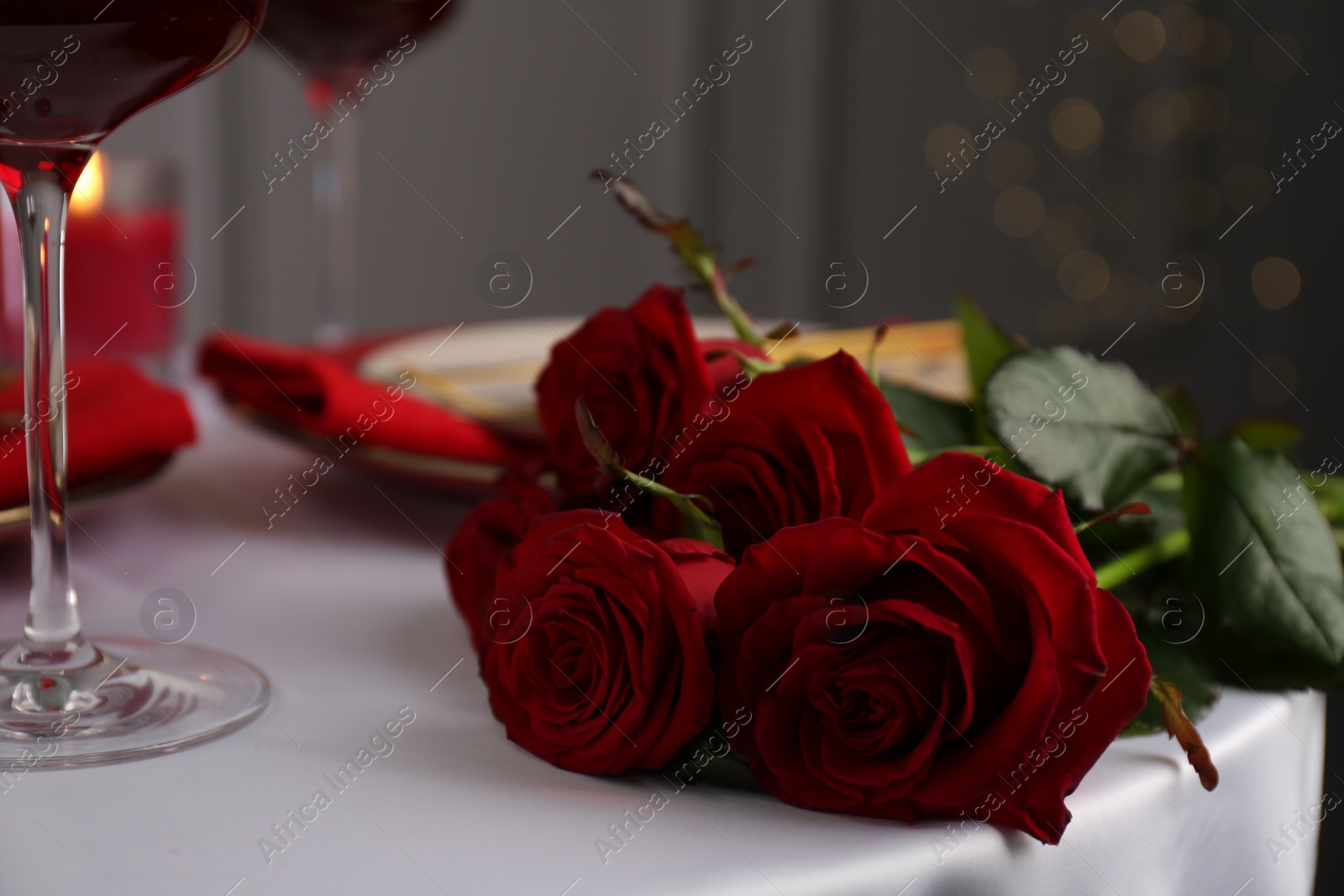 Photo of Beautiful red roses on white table indoors, closeup