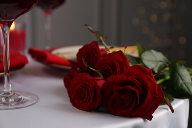 Beautiful red roses on white table indoors, closeup