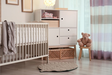 Modern room interior with crib and wooden crates under cupboard. Eco style