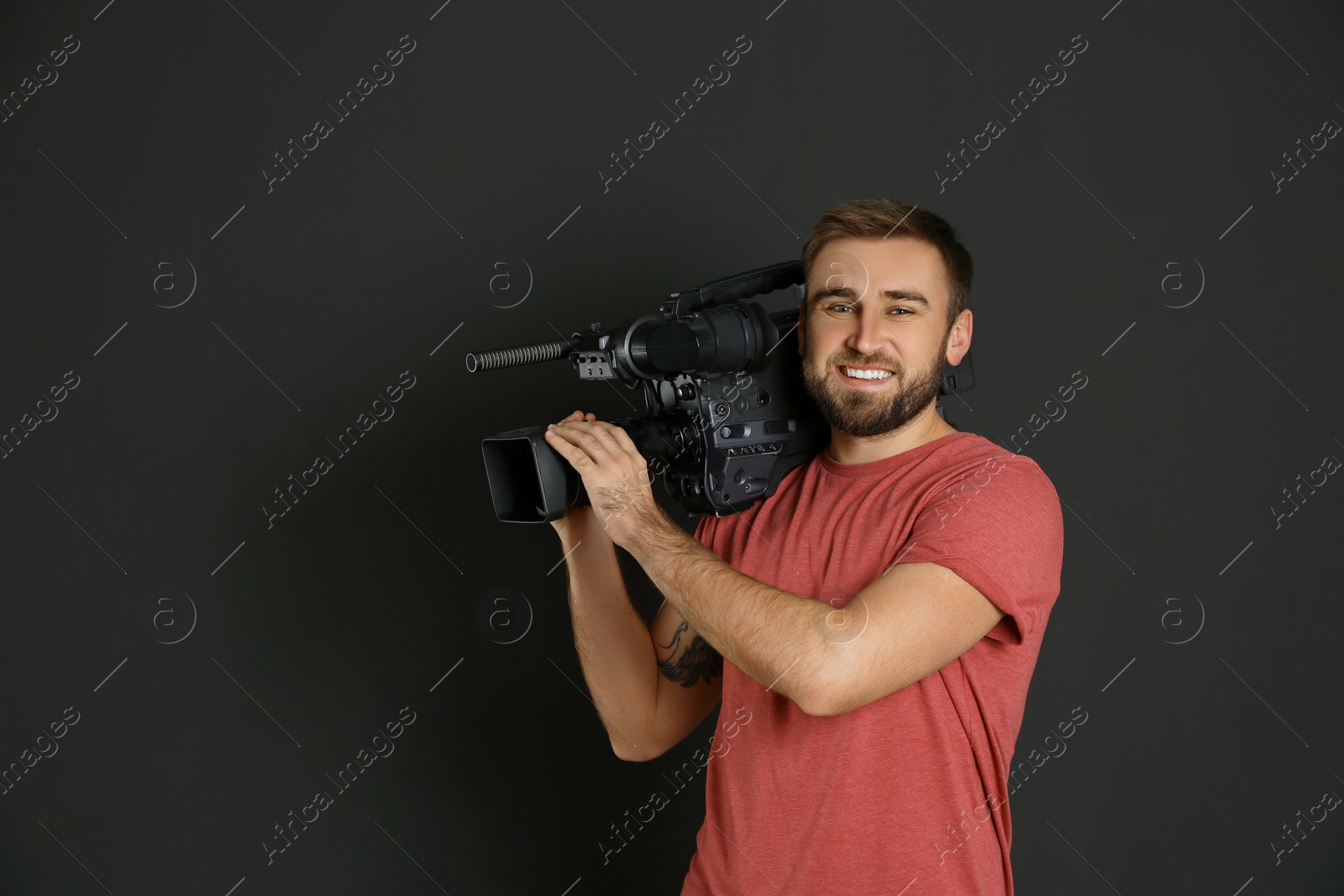 Photo of Operator with professional video camera on black background