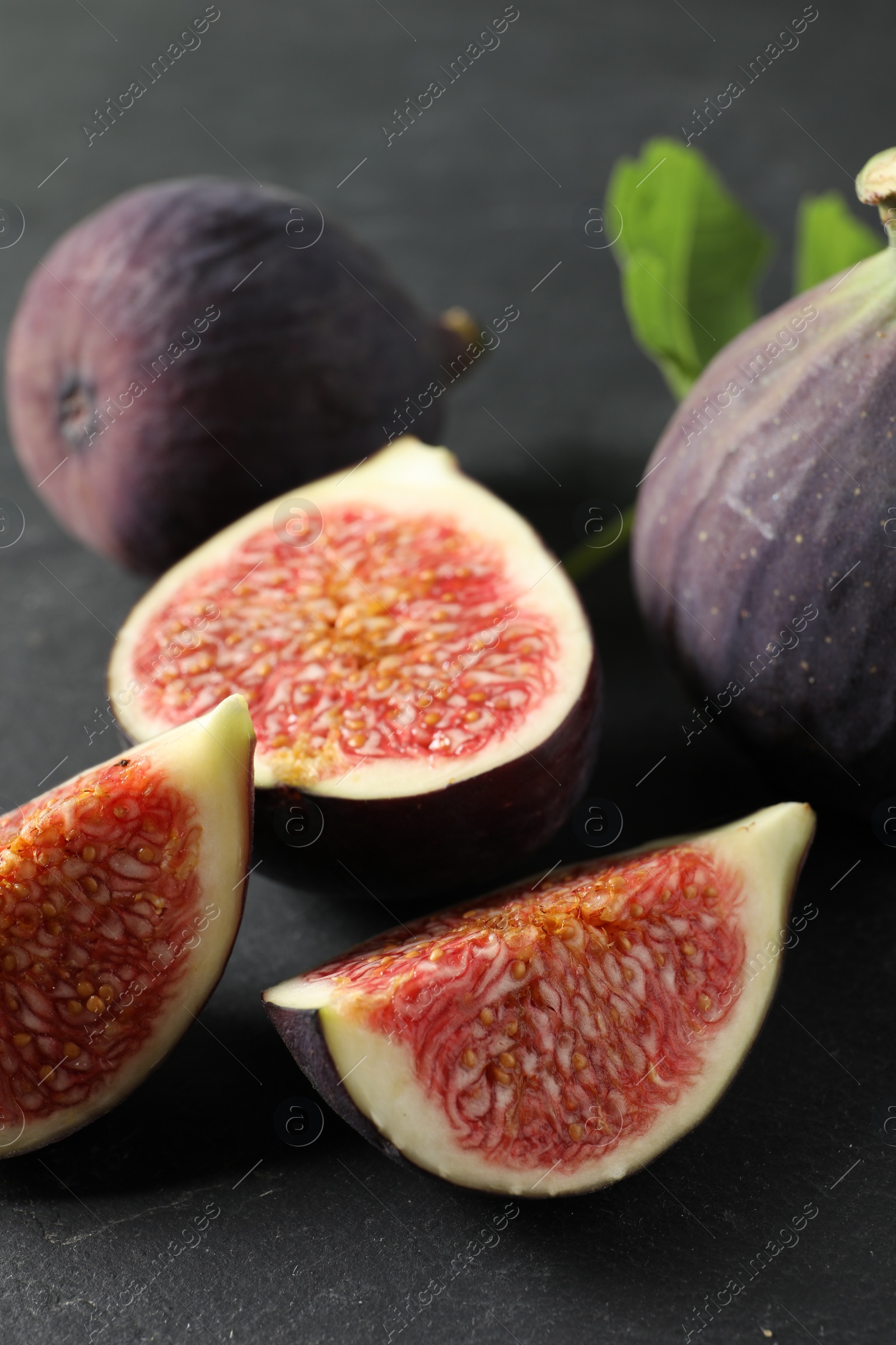 Photo of Fresh ripe figs on black table, closeup