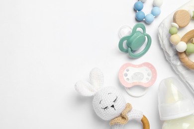 Photo of Flat lay composition with pacifiers and other baby stuff on white background. Space for text