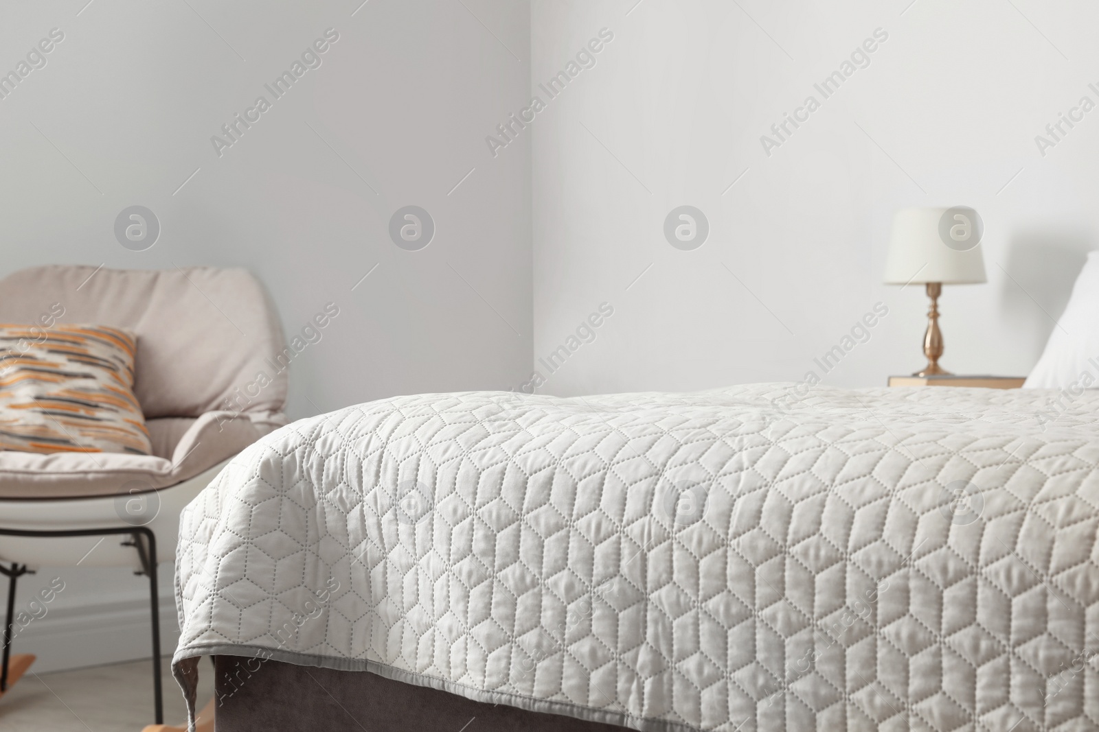 Photo of Large bed with blanket in modern apartment