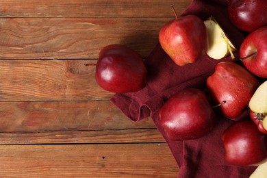 Fresh ripe red apples on wooden table, flat lay. Space for text