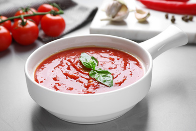 Delicious tomato sauce on light grey table