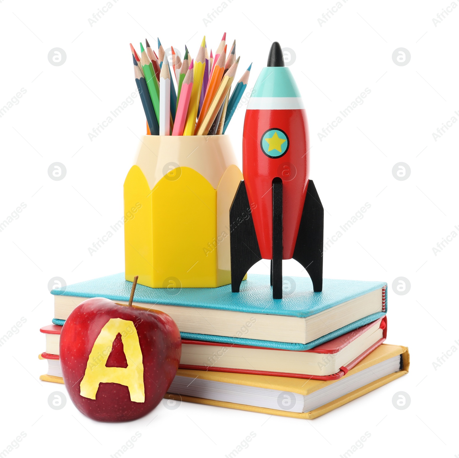 Image of Apple with carved letter A as grade. Bright toy rocket and school supplies on white background