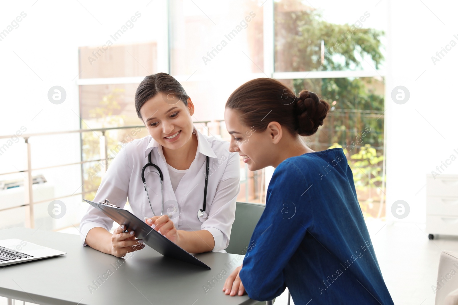 Photo of Young doctor consulting patient in modern hospital