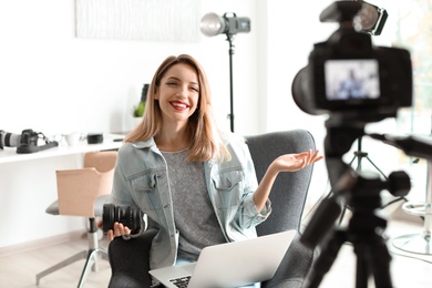 Photo of Female photo blogger recording video on camera indoors
