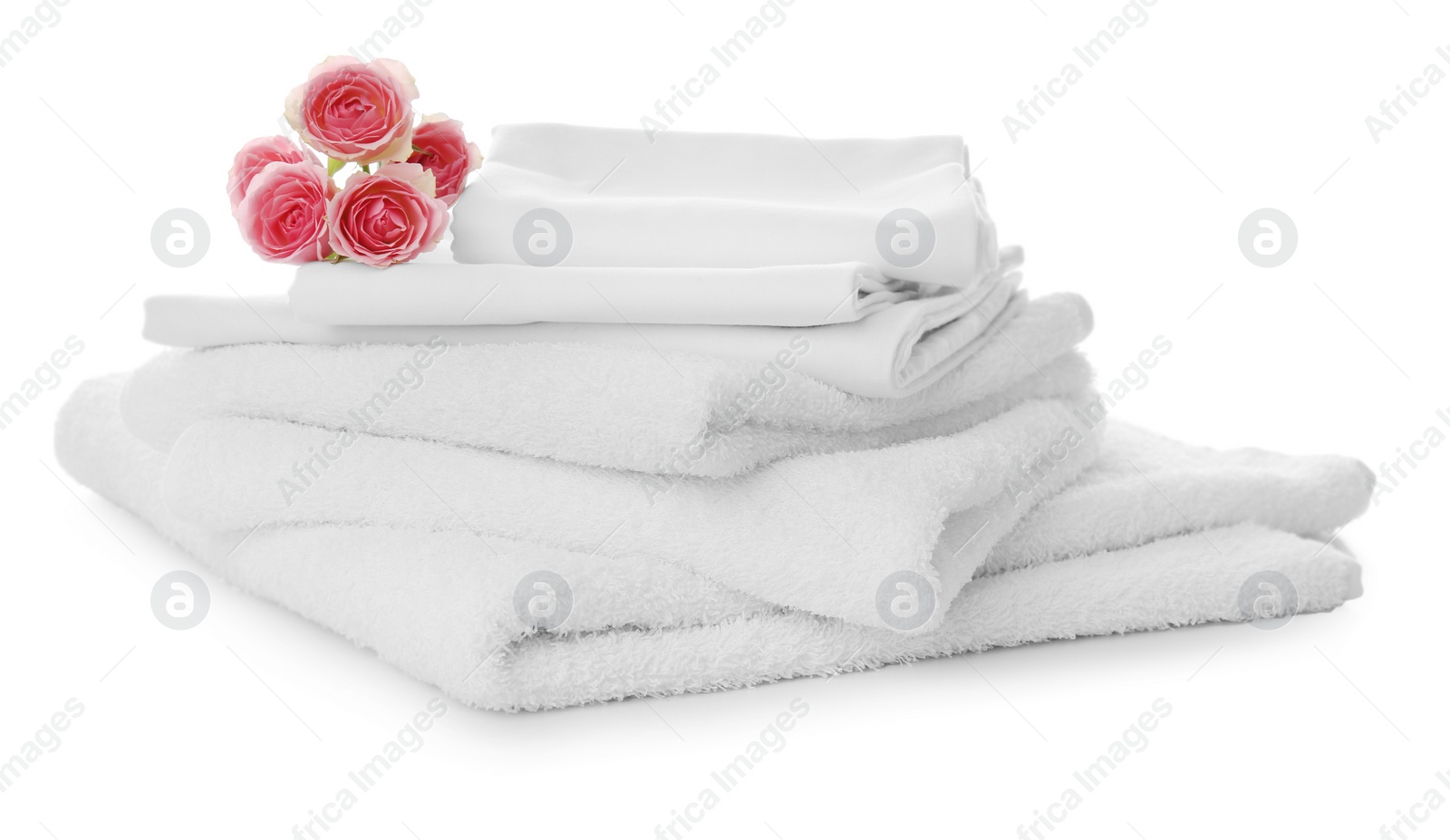 Photo of Stack of towels and bed sheets with roses on white background