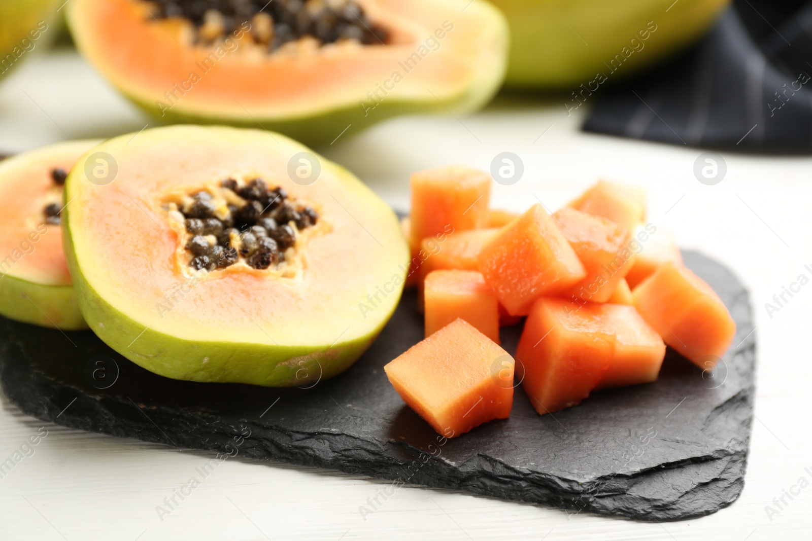 Photo of Fresh cut papaya fruits on white table, closeup