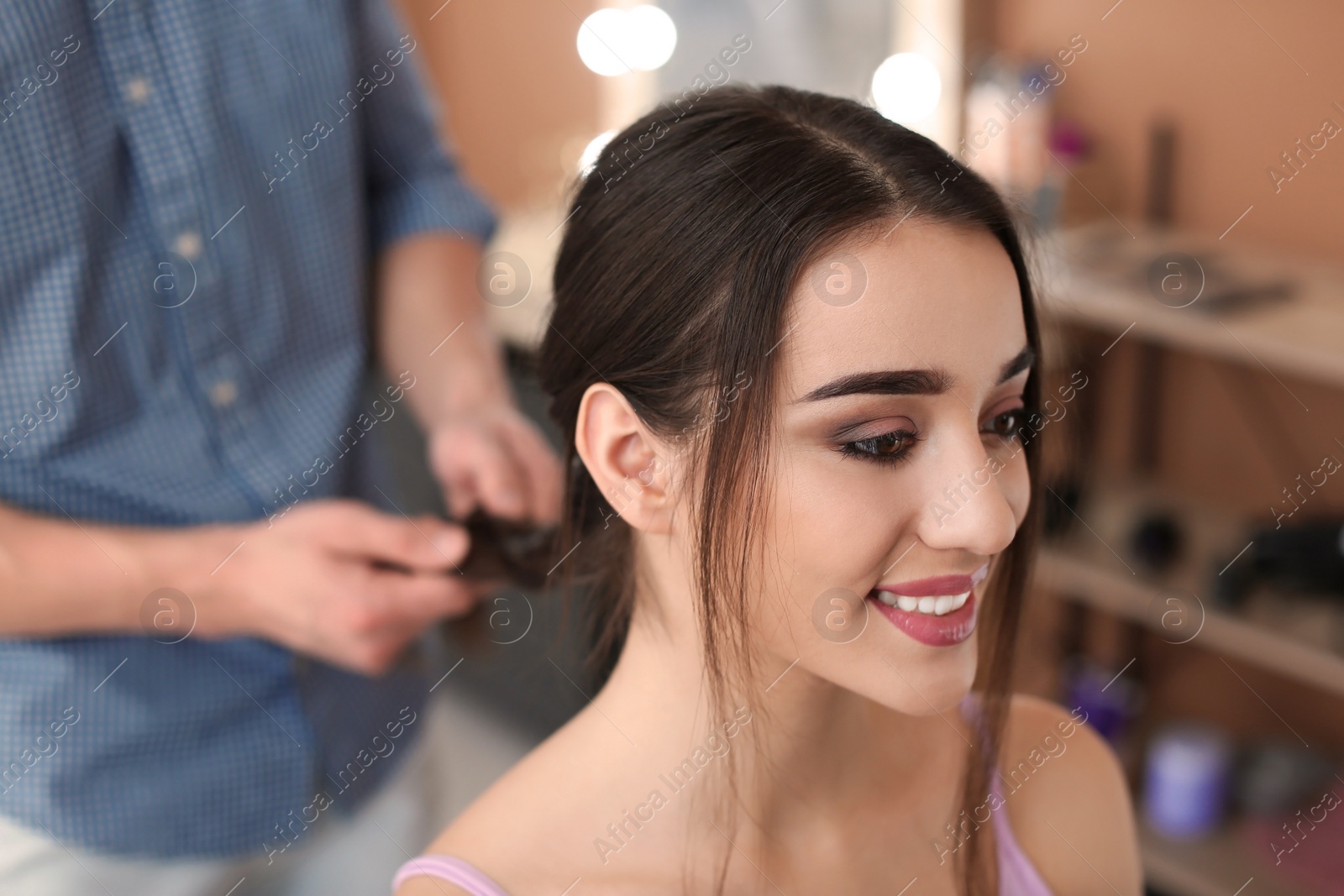 Photo of Professional hairdresser working with client in beauty salon