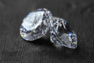 Photo of Beautiful shiny diamonds on dark gray table, closeup