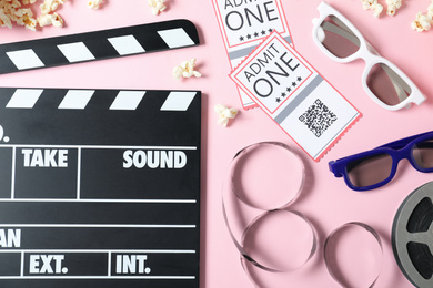 Photo of Flat lay composition with cinema tickets and clapperboard on pink background