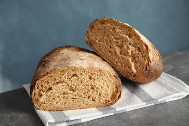 Photo of Cut loaf of bread on table against color background