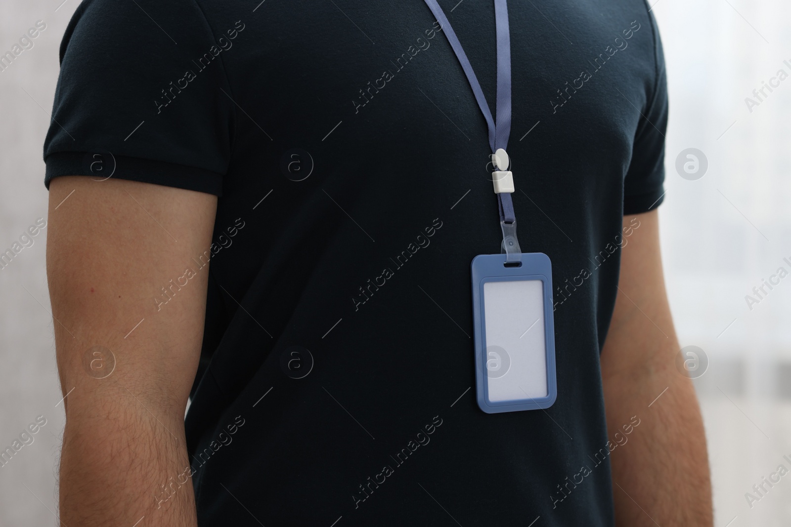 Photo of Man with blank badge indoors, closeup view