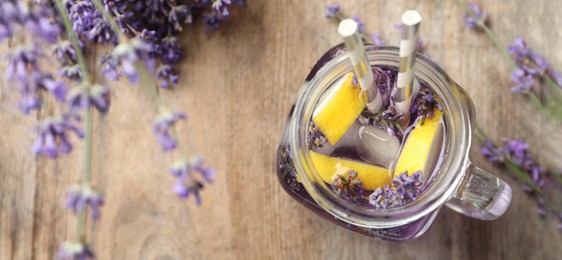 Image of Fresh delicious lemonade with lavender in mason jar on wooden table, flat lay with space for text. Banner design