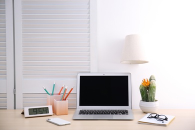 Photo of Modern workplace with laptop on table. Blank screen for mockup