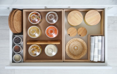 Open drawer with different jars indoors, top view. Order in kitchen