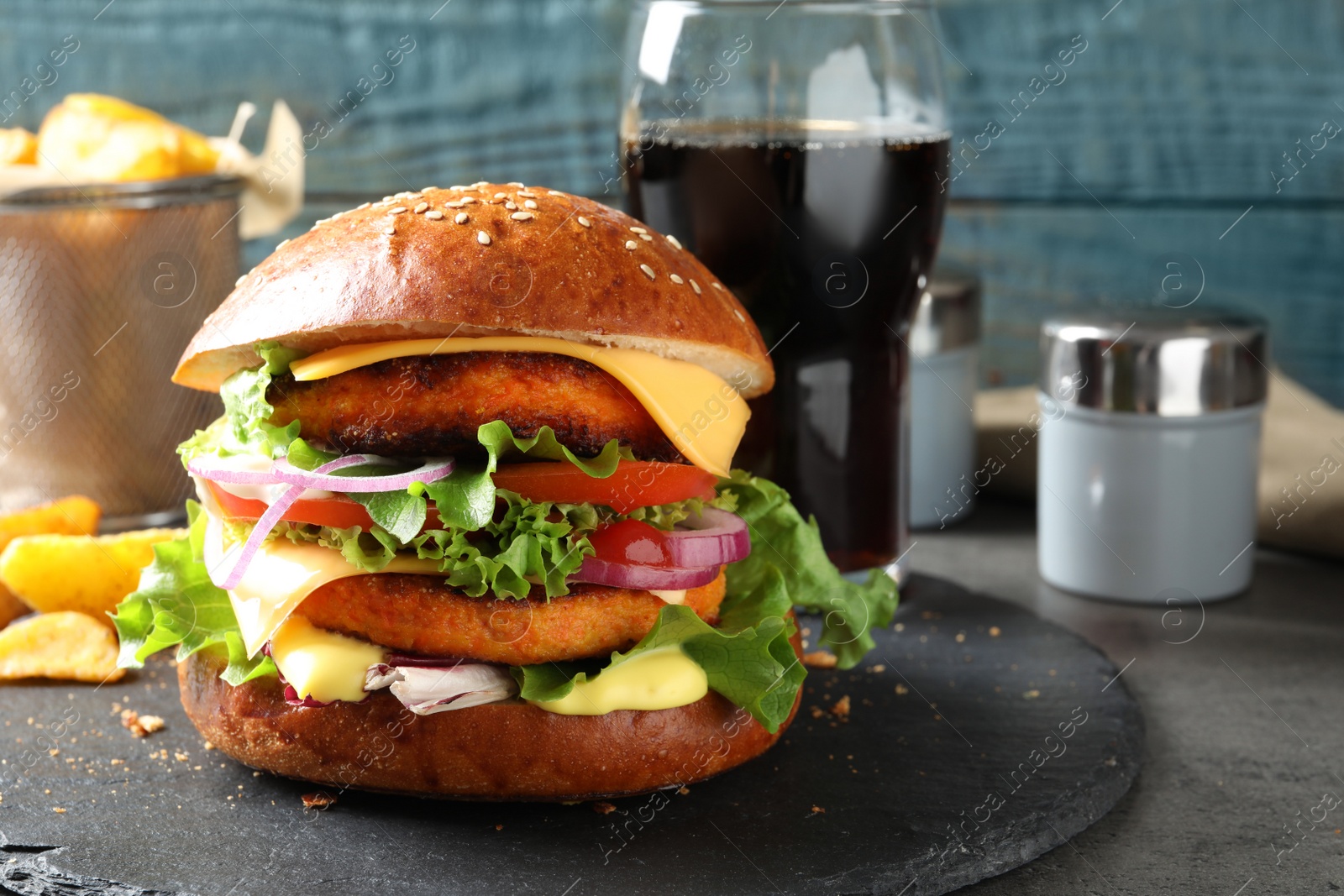 Photo of Slate plate with double vegetarian burger on table