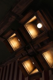 Photo of Stylish pendant lamps on ceiling in hotel room, low angle view