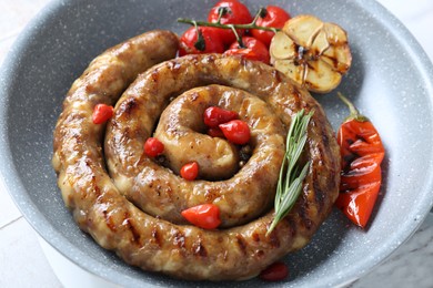 Photo of Delicious homemade sausage with garlic, tomatoes, rosemary and chili on table, closeup