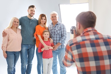 Professional photographer taking photo of family in studio