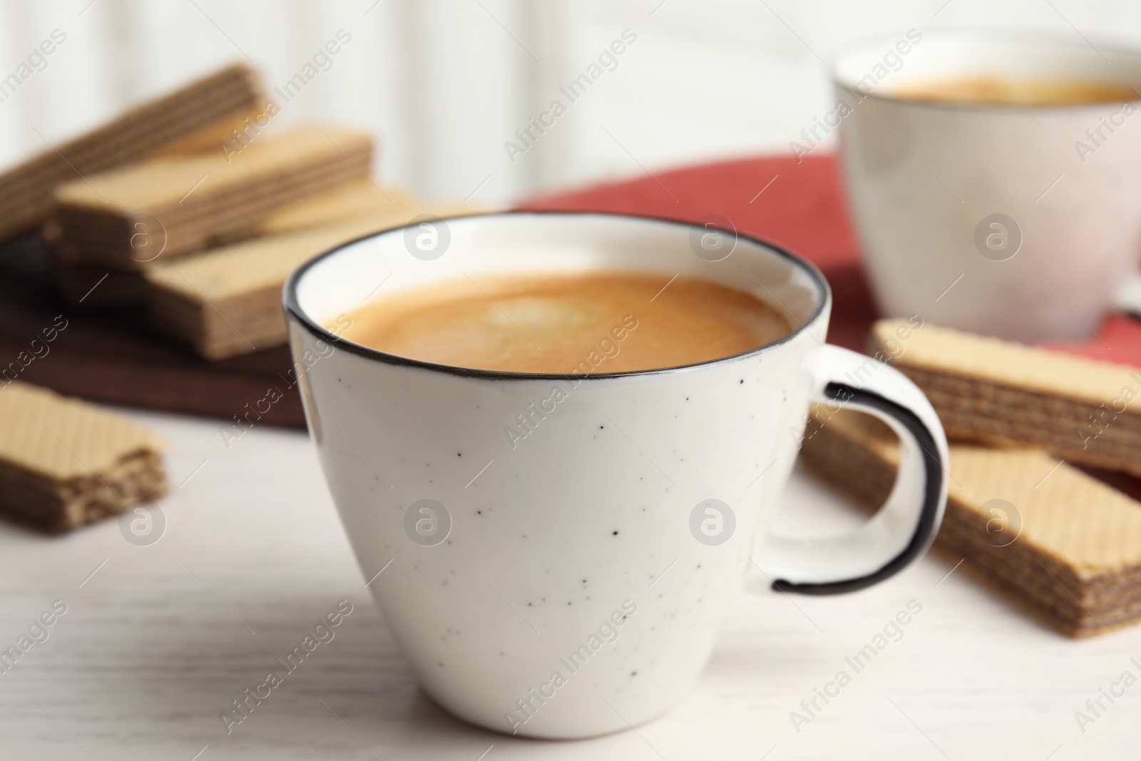 Photo of Delicious coffee and wafers for breakfast on white wooden table