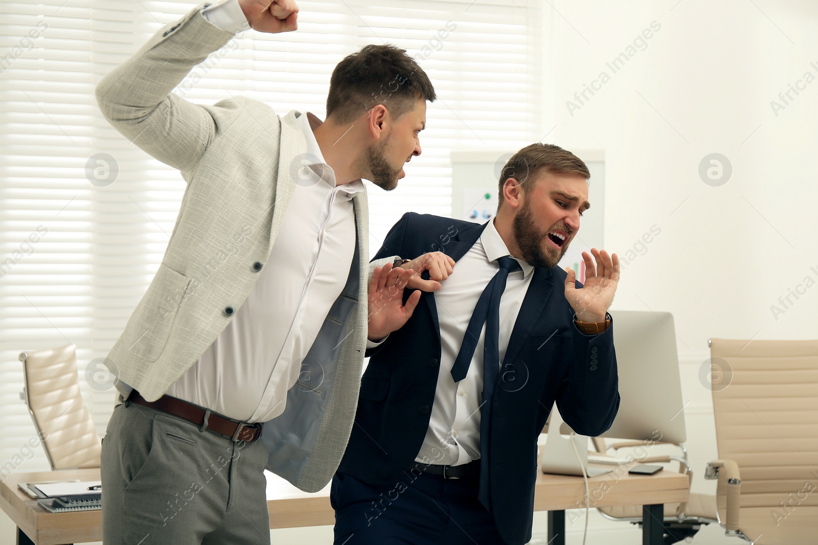 Photo of Emotional colleagues fighting in office. Workplace conflict