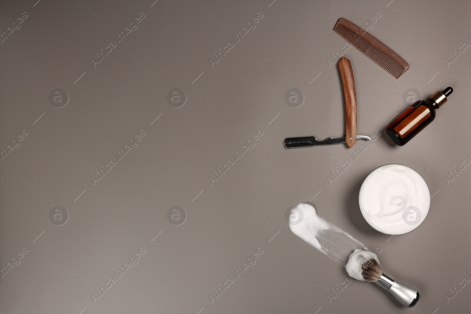 Photo of Set of men's shaving tools and foam on gray table, flat lay. Space for text