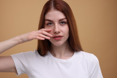 Photo of Portrait of beautiful woman with freckles on beige background