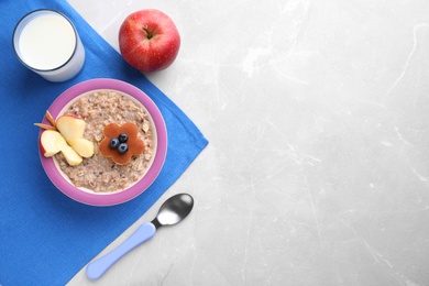 Photo of Top view of tasty porridge served with apple and milk on marble table, space for text. Kids breakfast idea