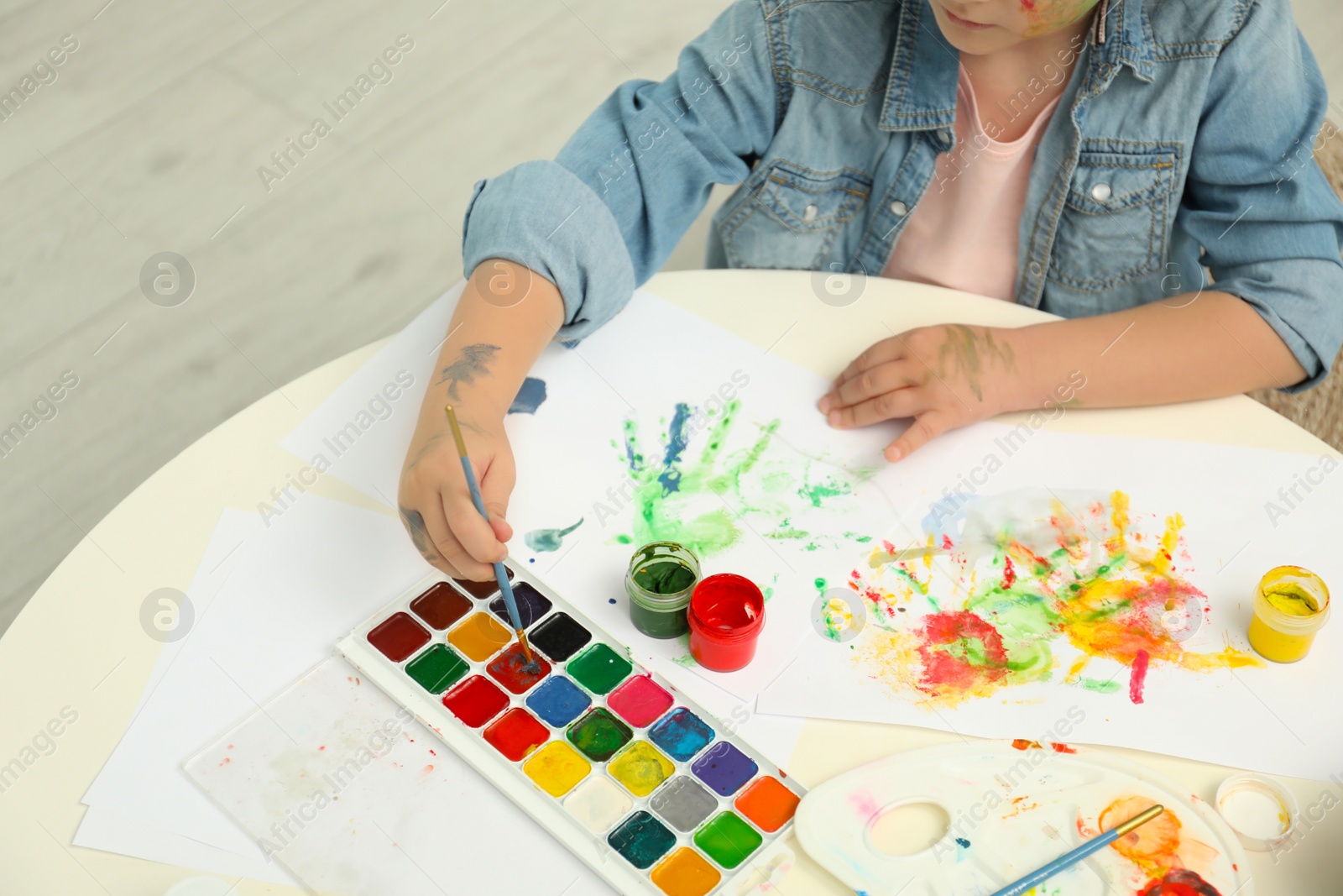 Photo of Little child painting at light table, closeup