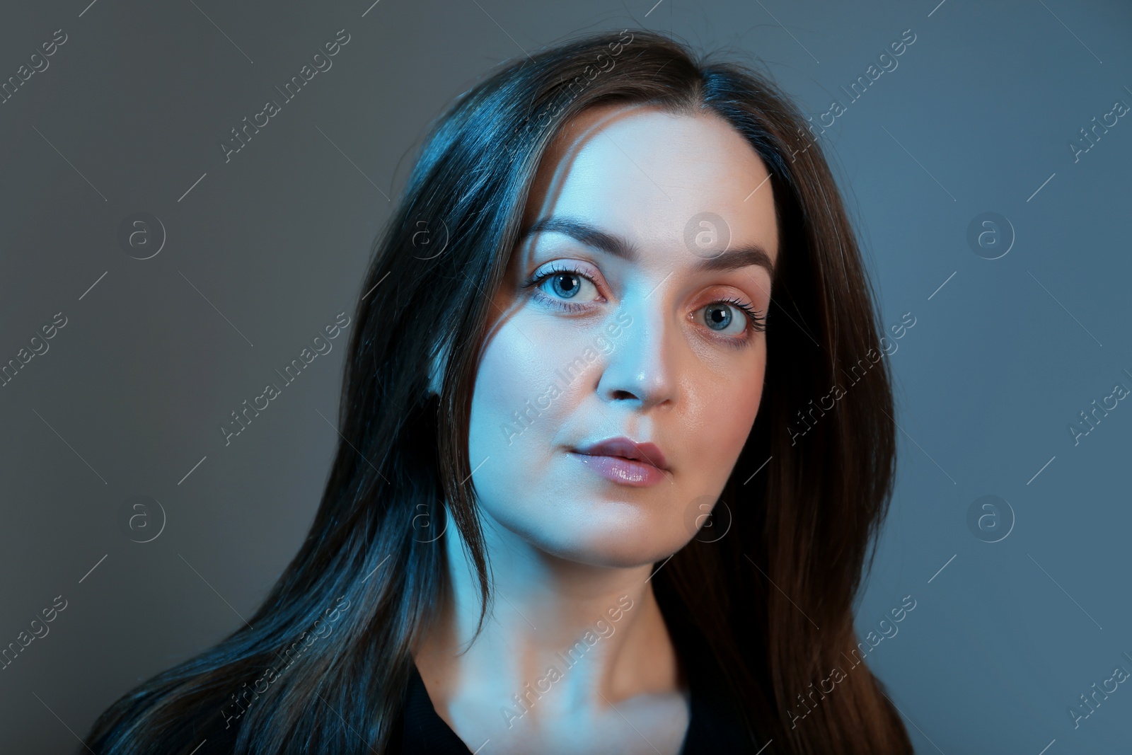 Photo of Portrait of beautiful young woman on color background with neon lights