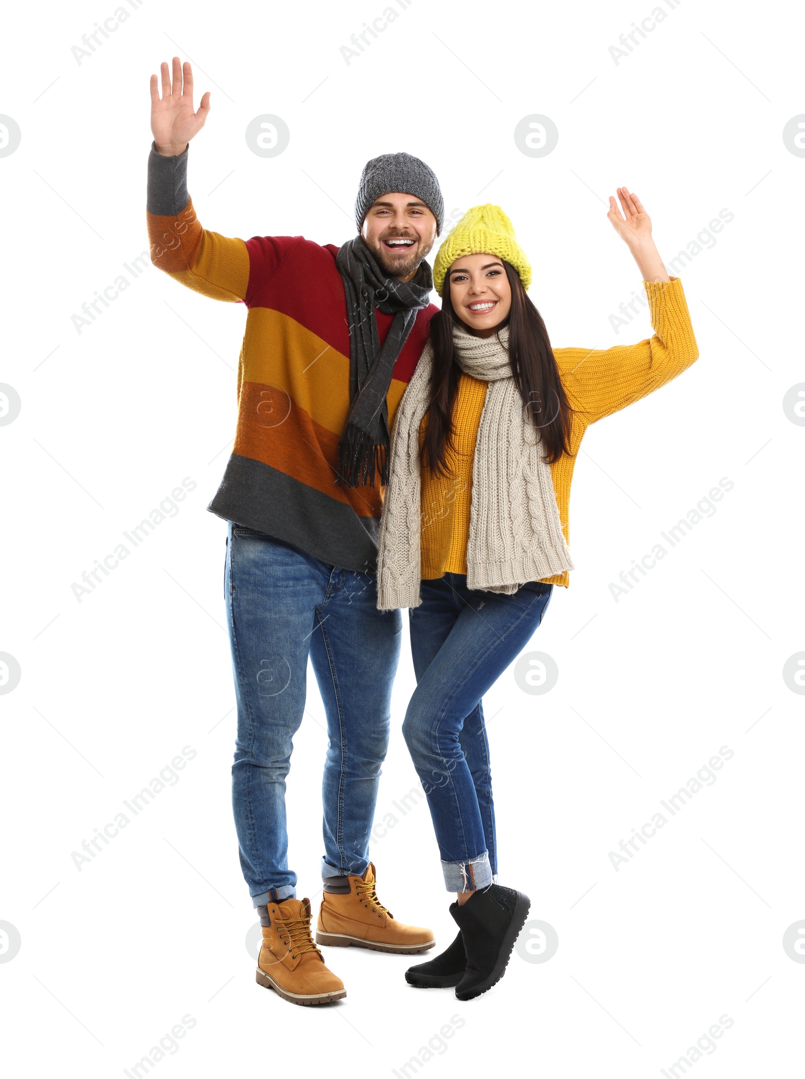 Photo of Happy young couple in warm clothes on white background. Winter vacation