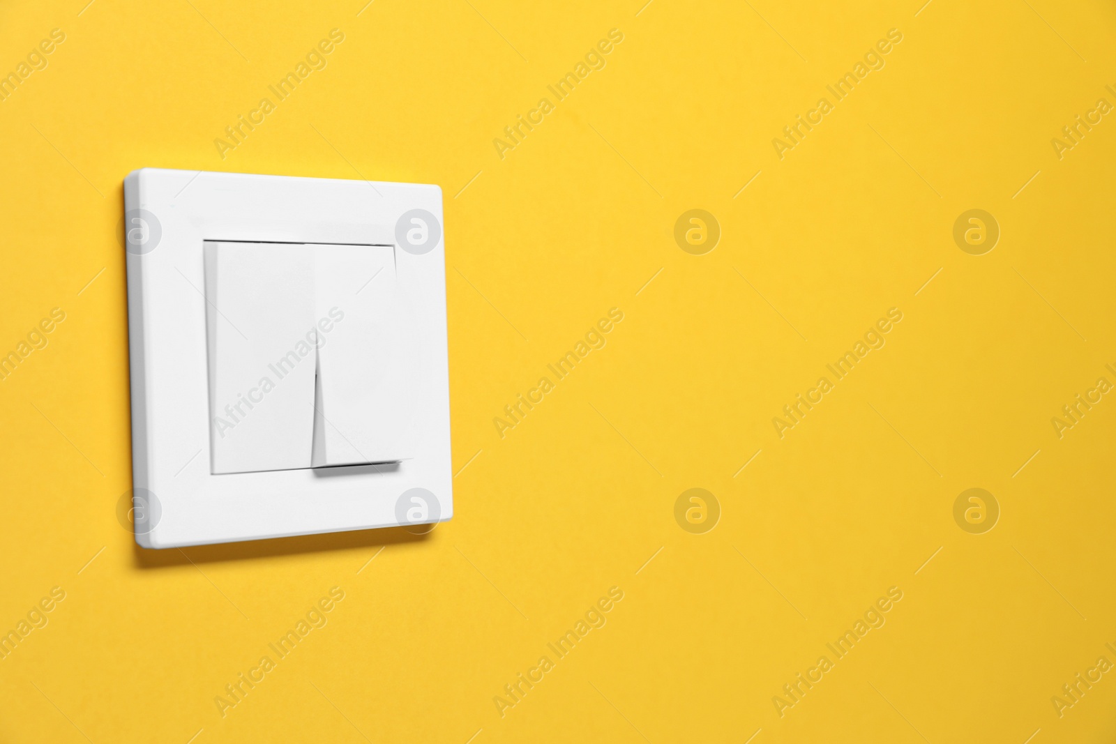 Photo of Modern plastic light switch on orange background. Space for text