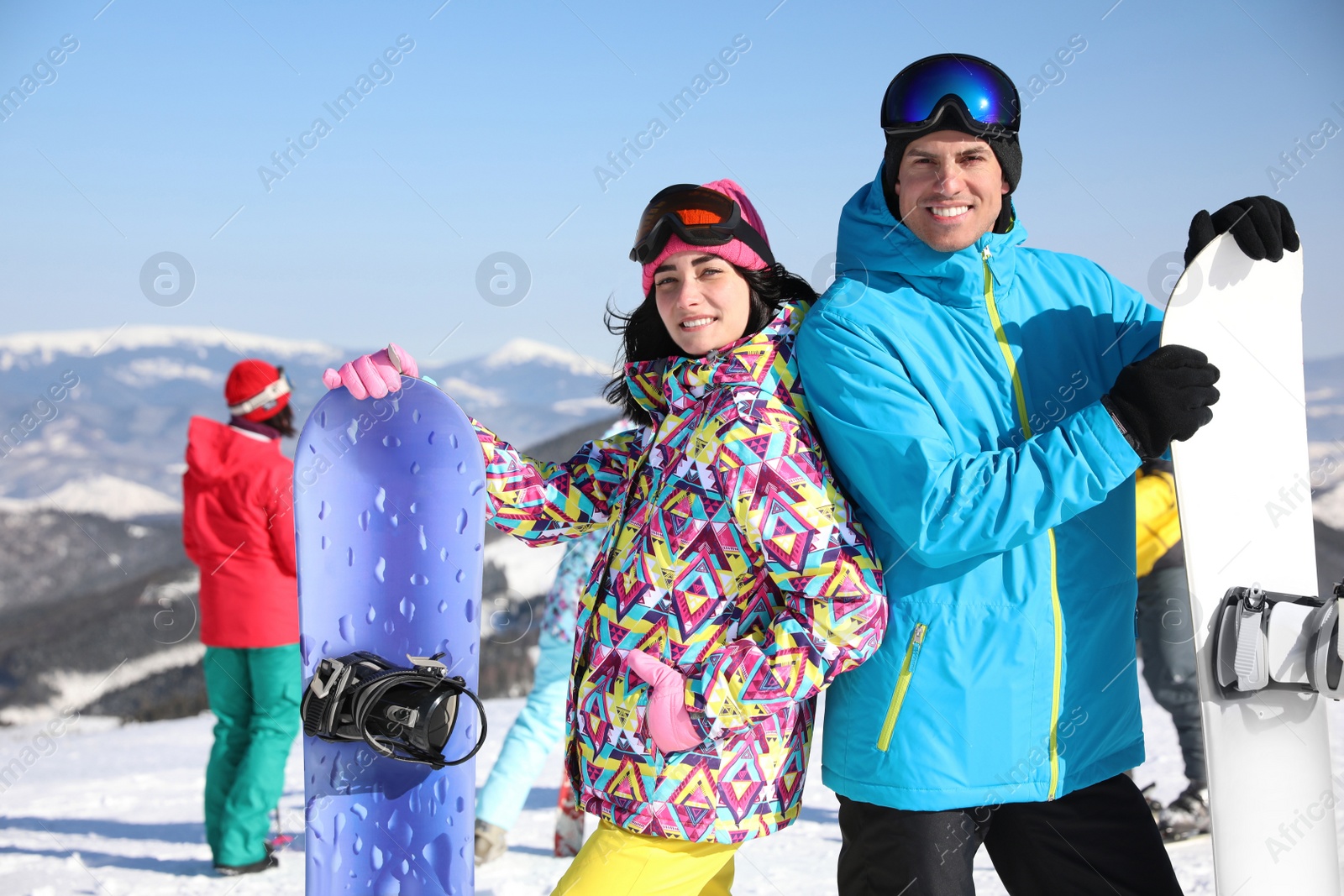 Photo of Couple with snowboards at ski resort. Winter vacation