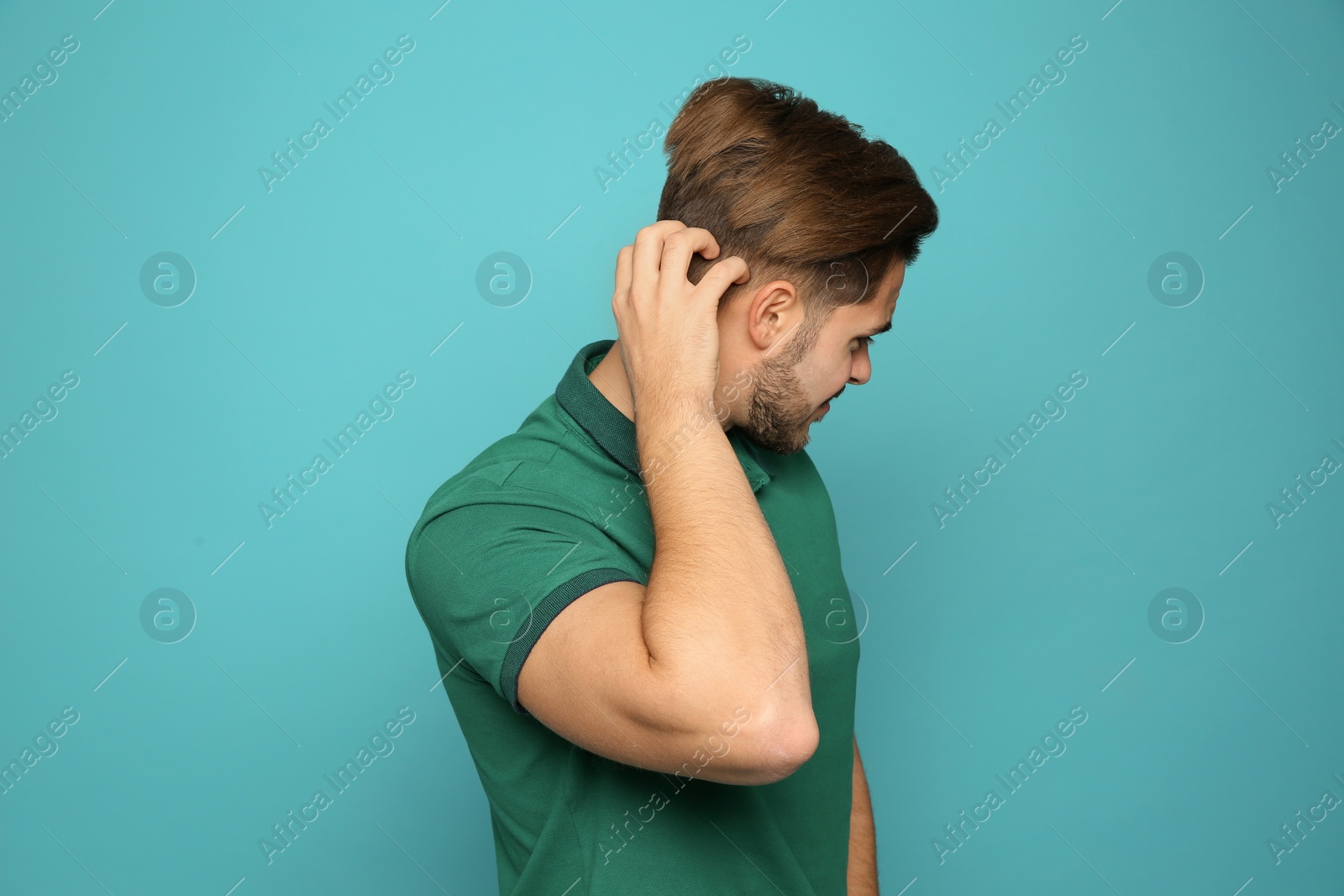 Photo of Young man scratching head on color background. Annoying itch