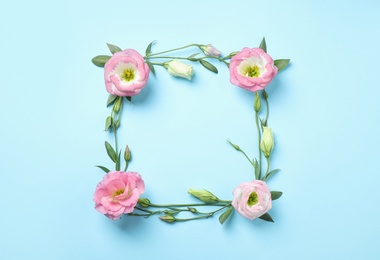 Photo of Flat lay composition with beautiful Eustoma flowers on light blue background, space for text