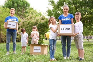 Photo of Volunteers and kids with donation boxes in park