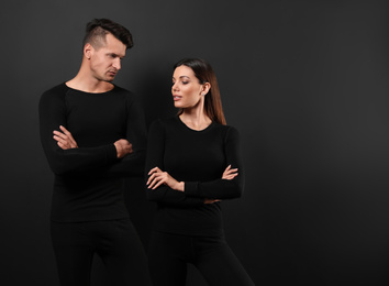 Couple wearing thermal underwear on black background